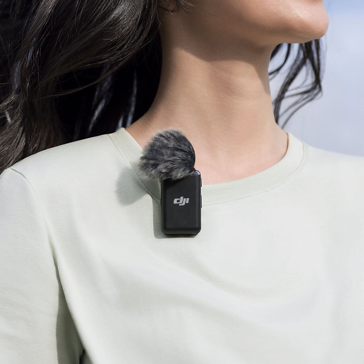 woman in a white shift with a DJI microphone on her collar