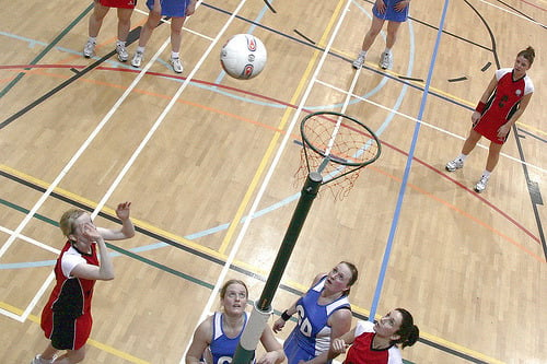 women playing netball and looking up at the basket